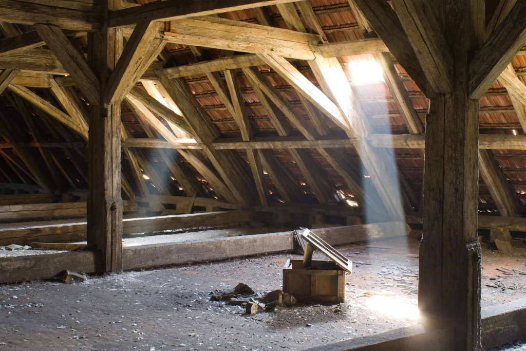 Empty rustic attic space with wooden beams and natural light